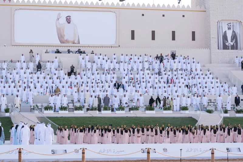 Panoramic view of official ceremony grandstand during national anthem and cultural performances in Al Wathba