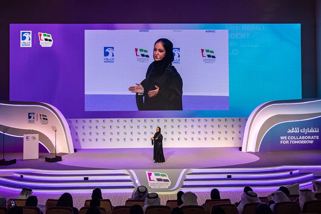 Attendees walking through illuminated entrance portal featuring Emirati Women's Day signage built by Evolution Events