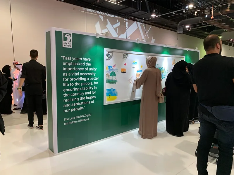 Emirati women painting colourful geometric artworks during an interactive Emirati Women’s Day activity
