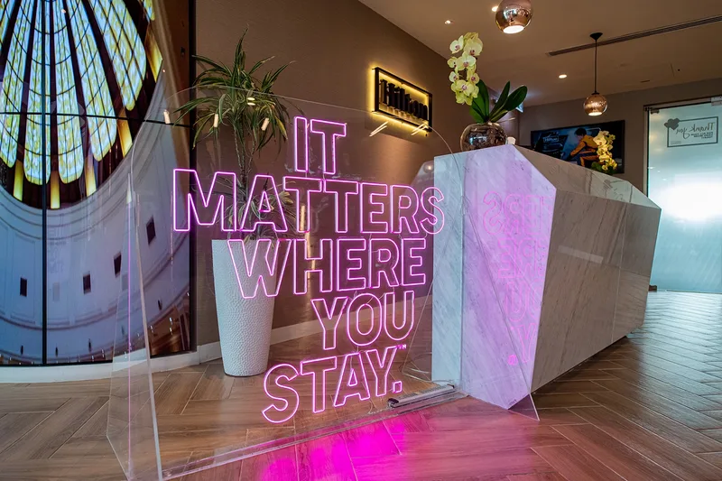 Custom neon signage and artistic backdrops enhancing Hilton's experiential brand environment