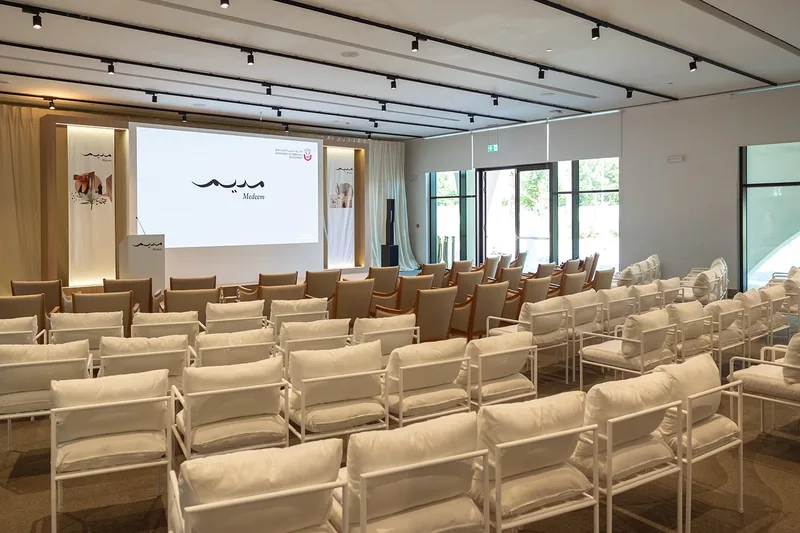 Modern family development initiative launch stage with warm wood finishes in Abu Dhabi