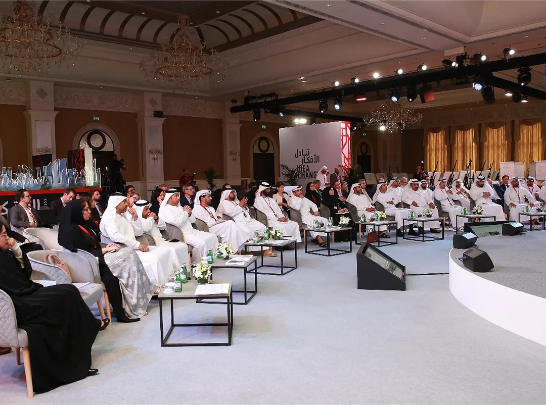 Wide-angle shot of Abu Dhabi summit plenary hall filled with finance industry professionals