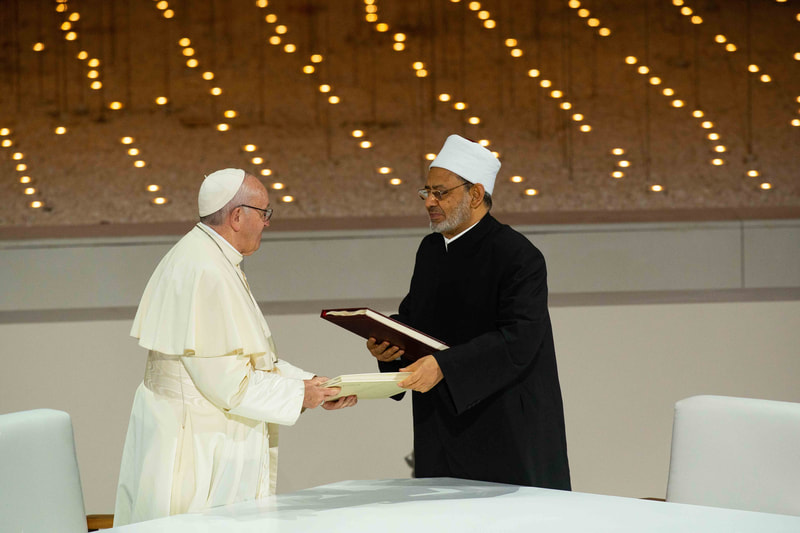 Image of Pope Francis and The Grand Imam of Al-Azhar Ahmad Al-Tayyeb passing documents to each other