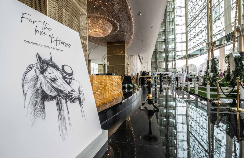 Image of the lobby area of the Meydan Hotel, with a billboard of the event name to the left