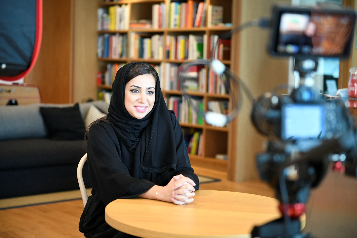 Photo of woman being interviewed in a library