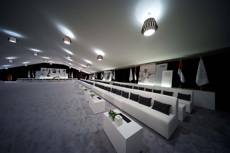 Interior shot of a majlis, with VIP furniture and hanging lighting with large scale printed backdrops