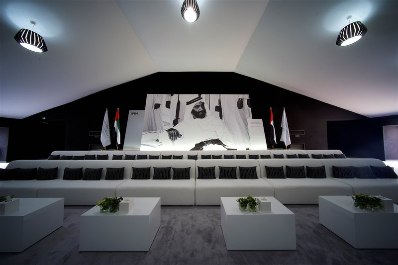 Interior shot of a majlis, with VIP furniture and hanging lighting with large scale printed backdrops